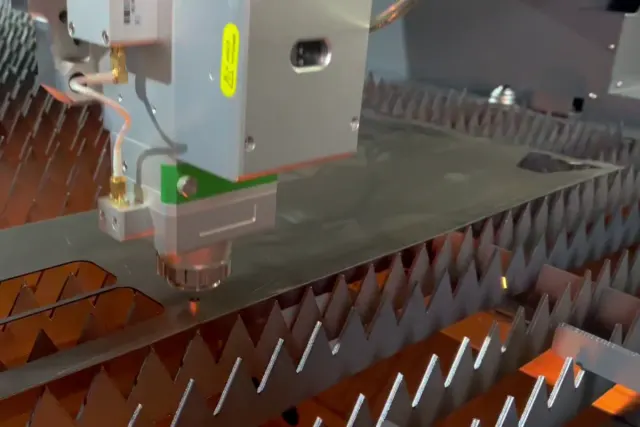 Tête de découpe laser fibre en pleine coupe d'une tôle acier